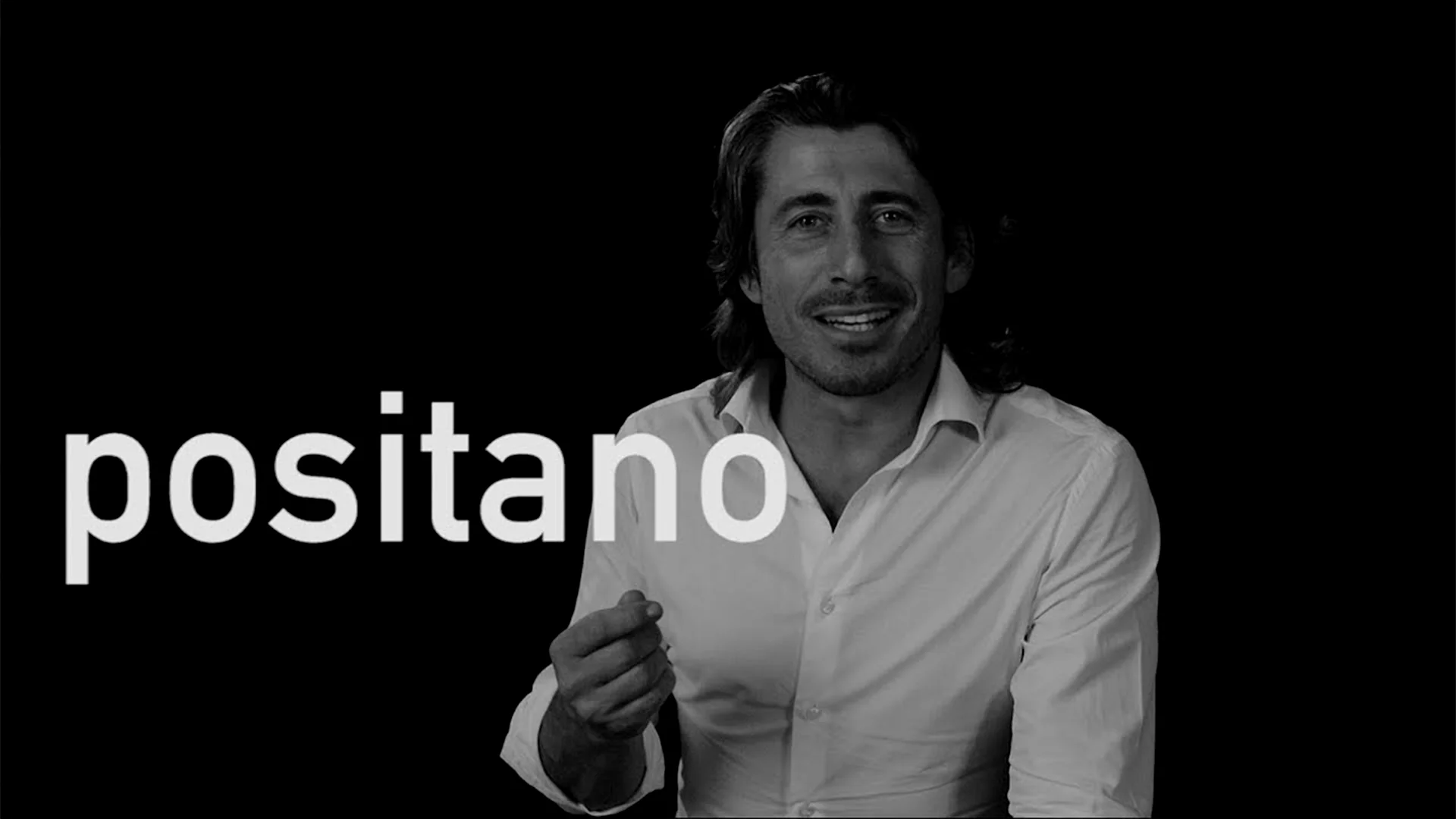 Luca in white shirt on dark background explaining Positano.