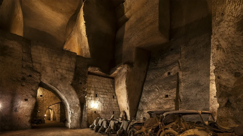 The underground passageways of the Bourbon Tunnel in Naples, featuring historic arches, dim lighting, and remnants of wartime artifacts.